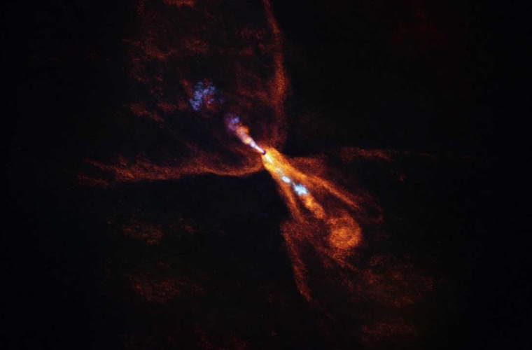 Die ALMA-Aufnahme von HOPS-315 zeigt Kohlenmonoxid (orange), das in einem schmetterlingsförmigen Wind vom Stern wegströmt. Ein schmaler Strahl aus Siliziummonoxid (blau) weist ebenfalls vom Stern weg.