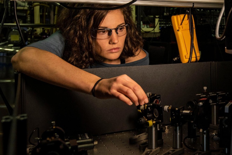 Abb.: Katie McCormick justiert einen Laserstrahl, mit dem ein Beryllium-Ion...