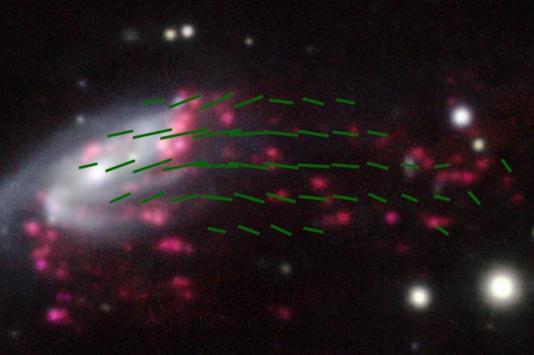 Abb.: Die Galaxie JO206 und ihr geordnetes Magnet­feld (grüne Linien) entlang...