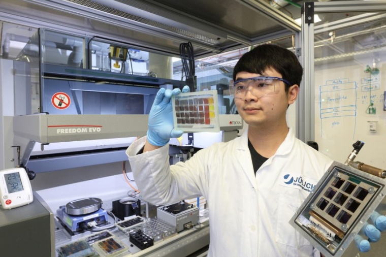 Abb.: Yicheng Zhao mit Perowskit-Solarzellen- und Dünn­schicht-Proben vor...